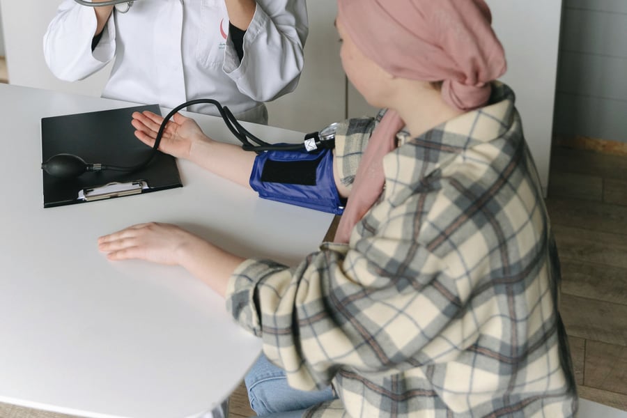 A clinician taking a patient's blood pressure with a cuff and stethoscope.