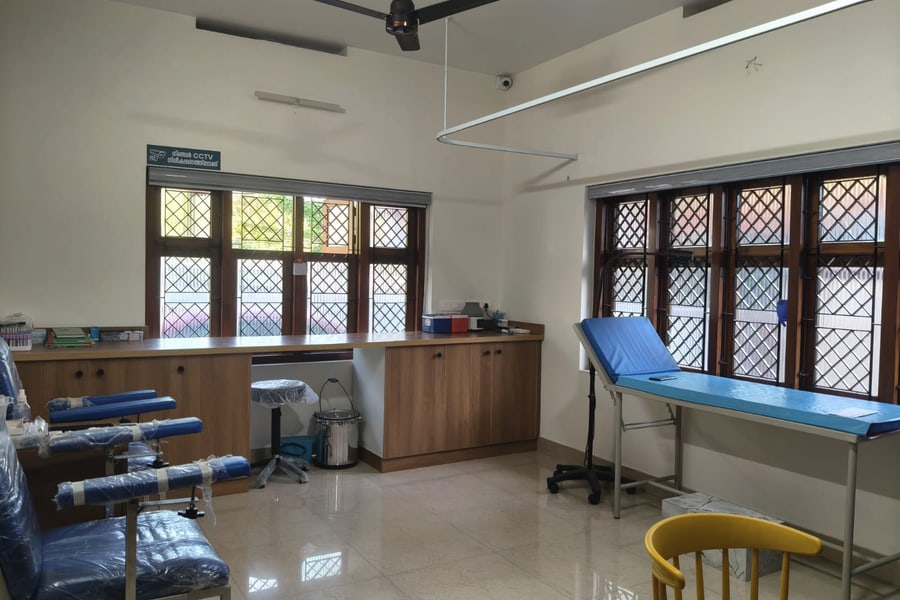 The sample collection room: an examination couch by the window, phlebotomy chairs, and a counter laid out with collection tubes.